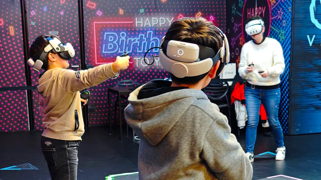 Gruppo di bambini e adulti che giocano con i visori per la realtà virtuale.