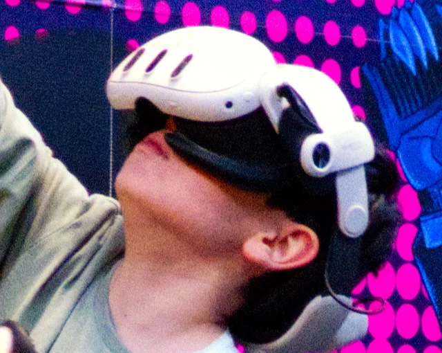 Bambino che indossa un visore per la realtà virtuale, inquadrato mentre guarda verso l’alto.